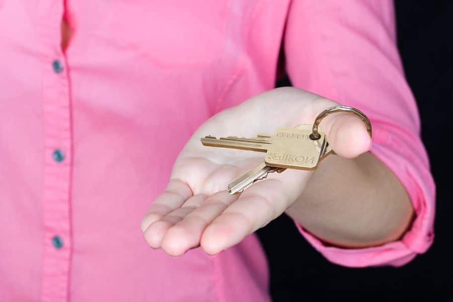 Seller holding out the keys to her house