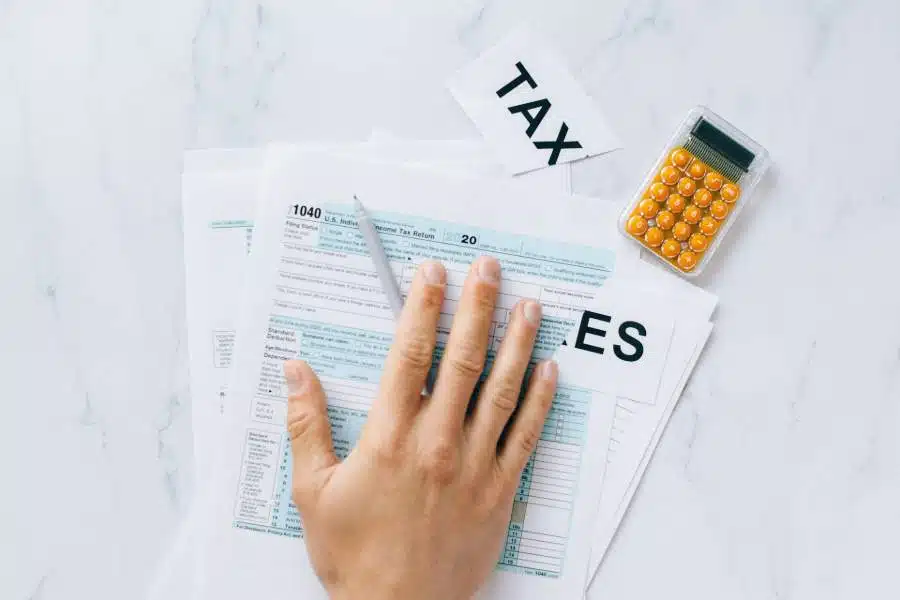 Hand on a pile of tax documents