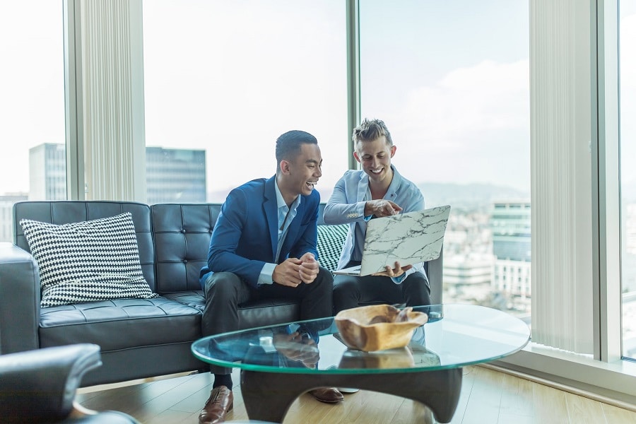 A client and realtor having a discussion while using a laptop