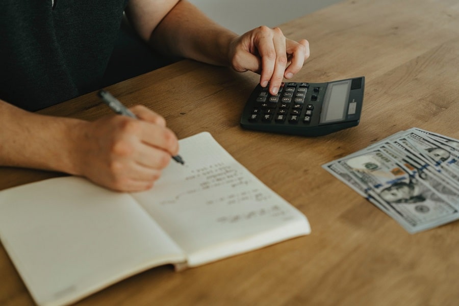 Person calculating real estate fees on a desk