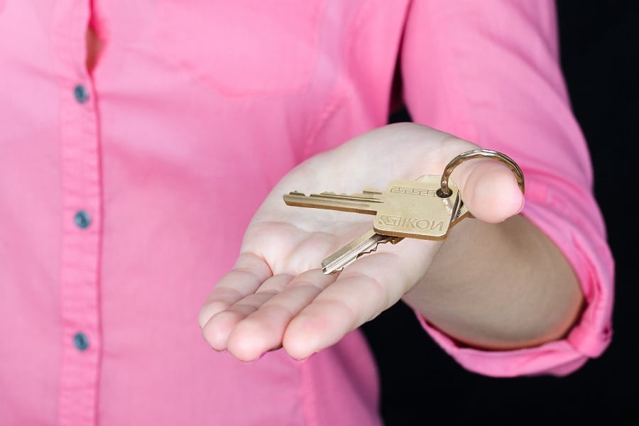 Woman in pink shirt holding a key