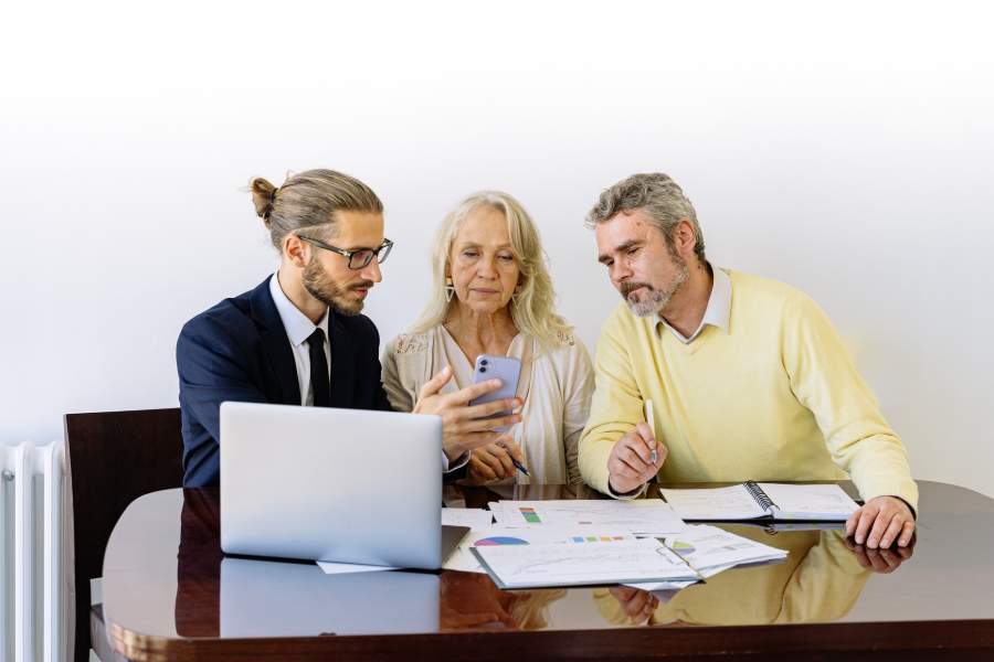 A flat fee realtor showing his phone to his clients