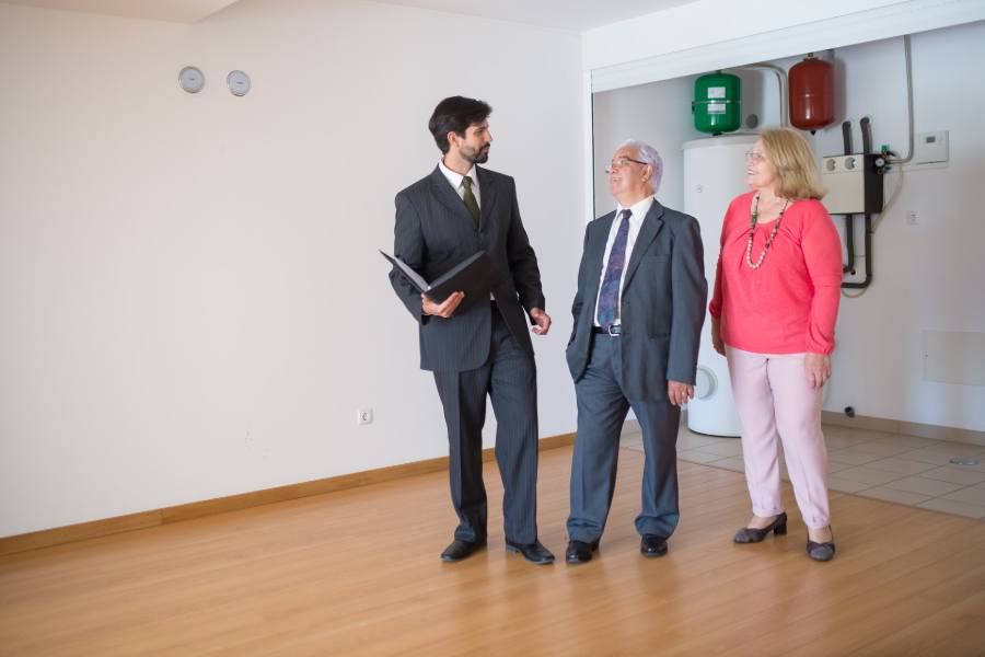 Realtor giving a house tour for an old couple