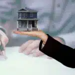 Person holding a small house model