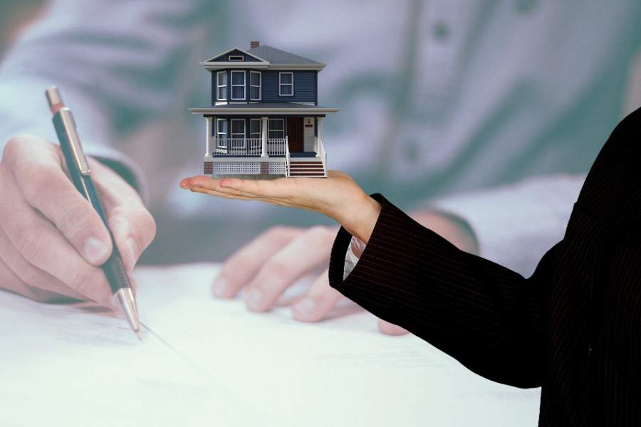 Person holding a small house model