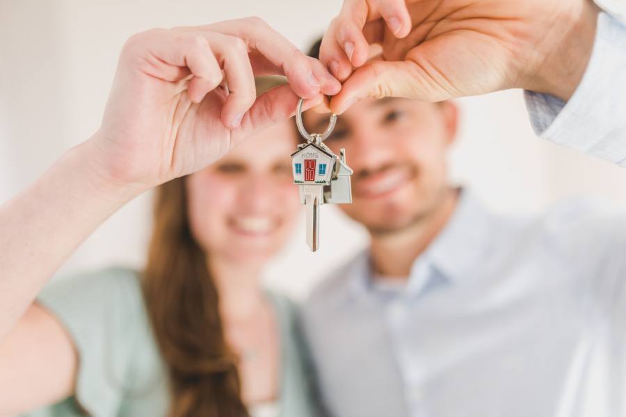 A couple both holding a house key