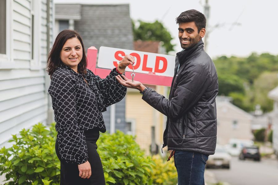 Realtor handing out the key to the new home owner