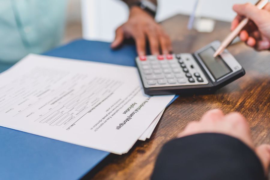 Person pointing to a calculator while discussing selling fees