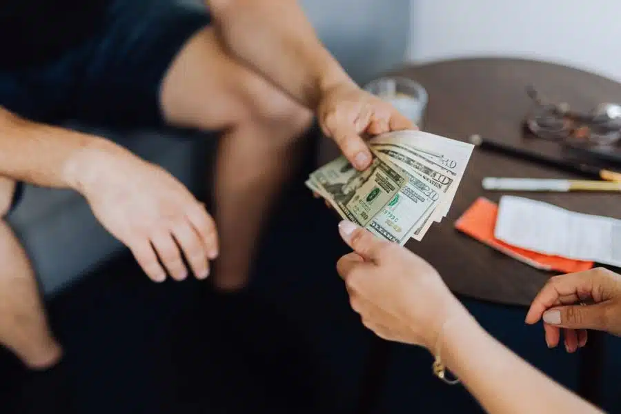 Man giving money to another person