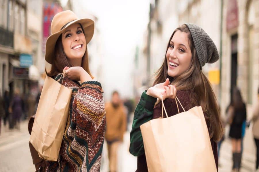 Two girls holding a brown shopping bag