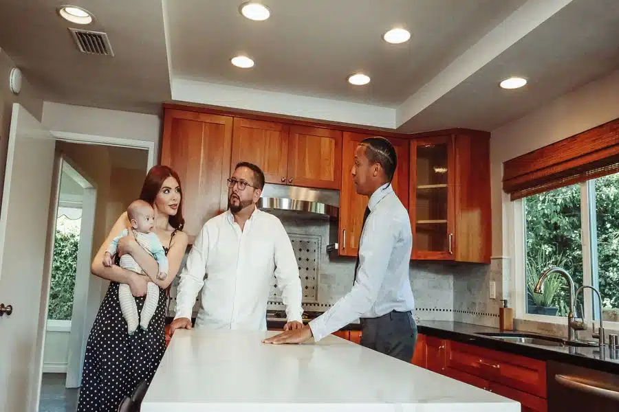 Couple talking to their realtor regarding how to offers to sell their house