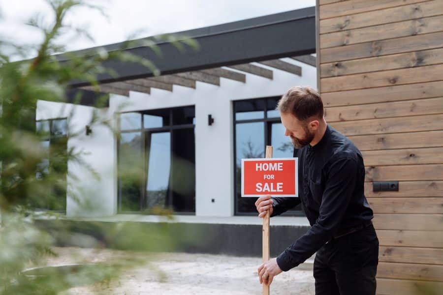 Man putting up a Home for Sale sign