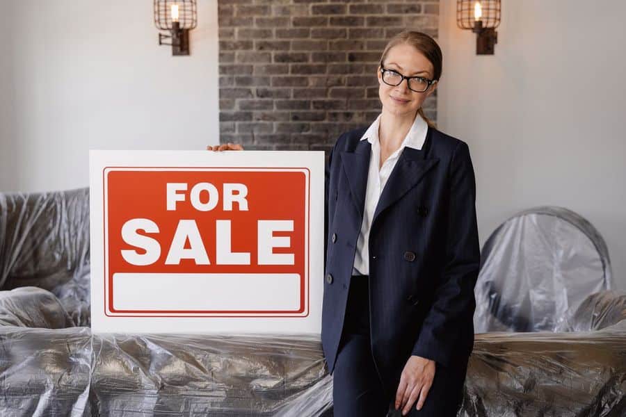 Real estate agent holding a for sale sign