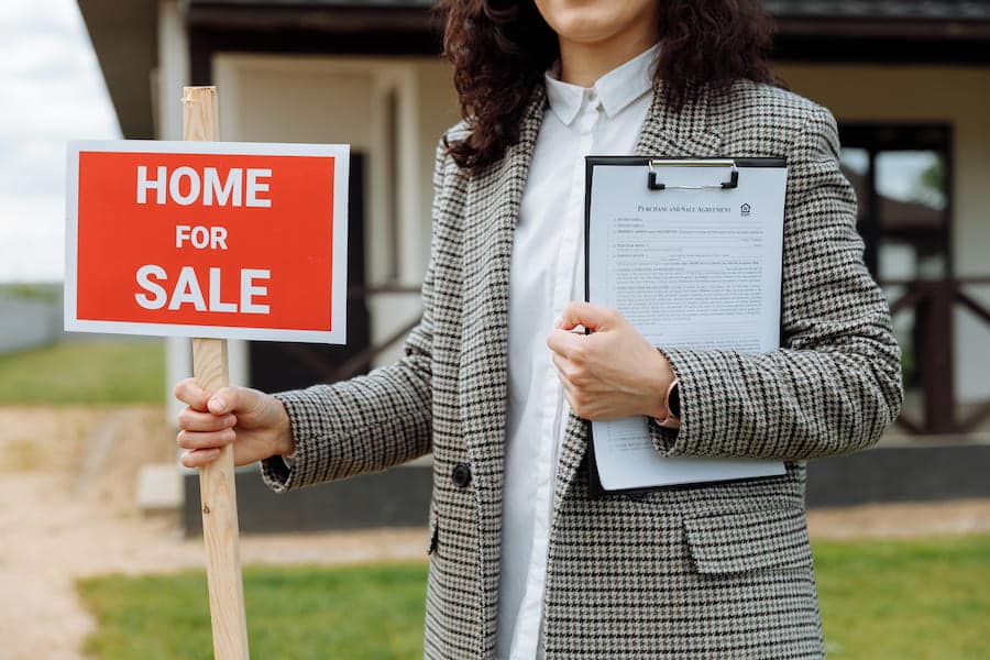 A realtor putting up the home fore sale sign