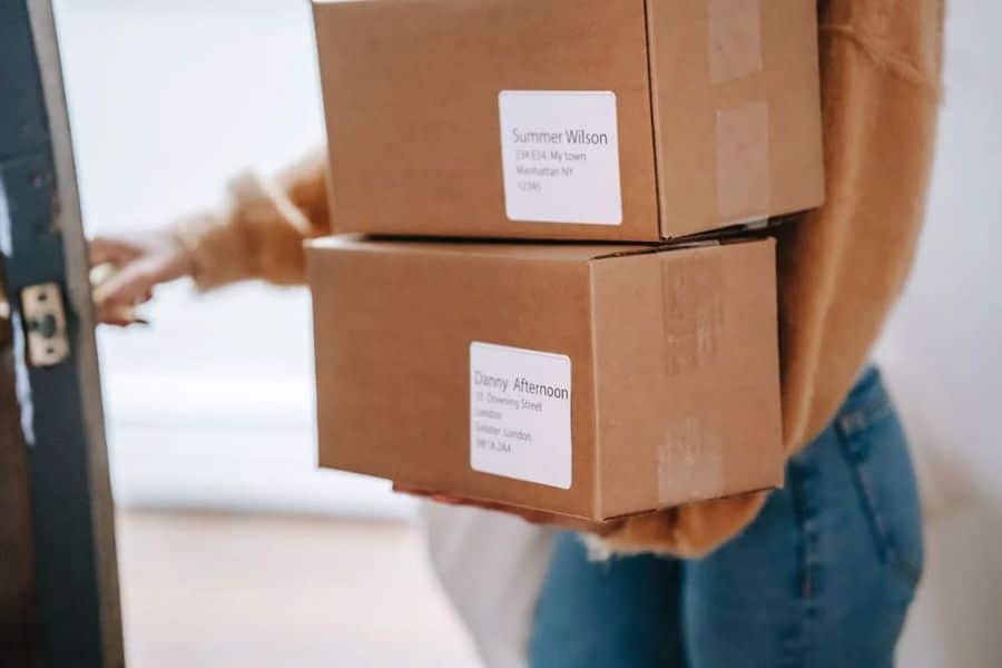 Woman holding packages with her address on it