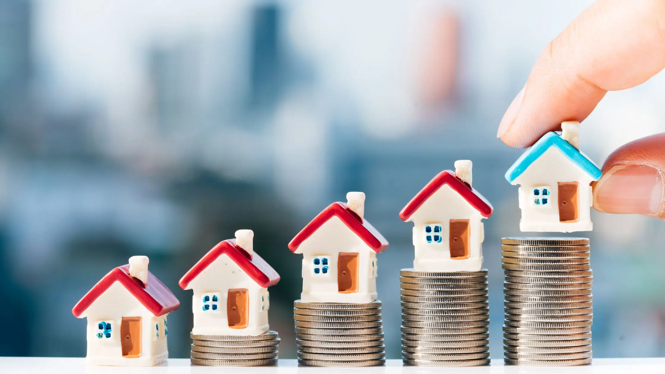 toy vacation home stacked up on coin columns as investment option