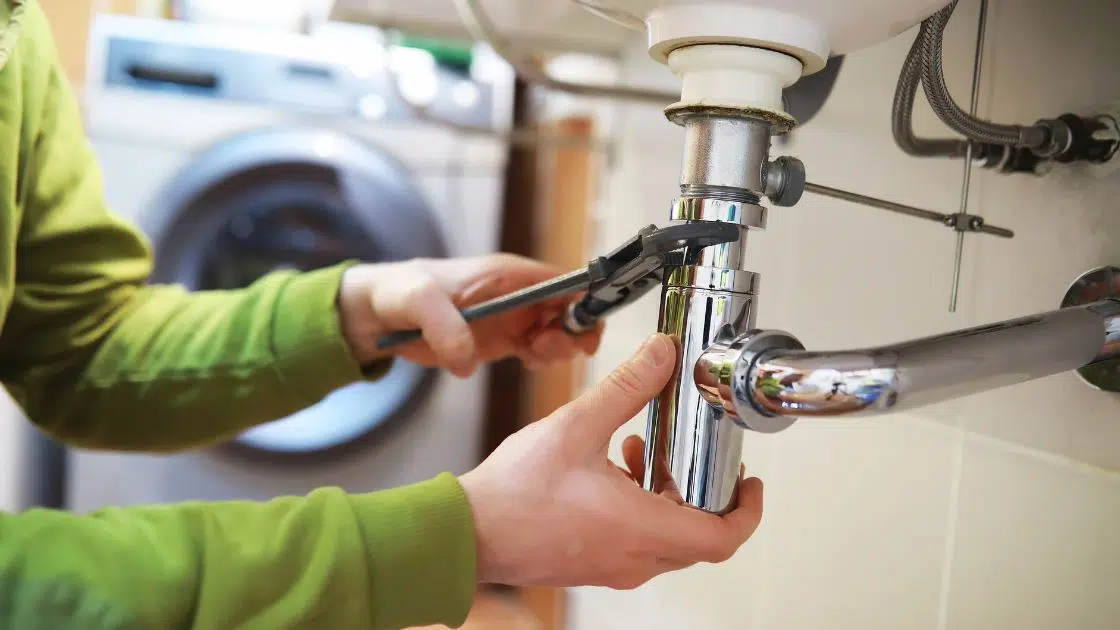 a plumber fixing basin pipes