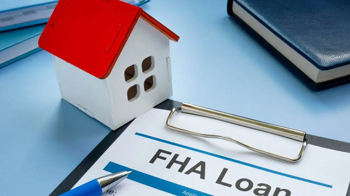 FHA loan application beside a toy home