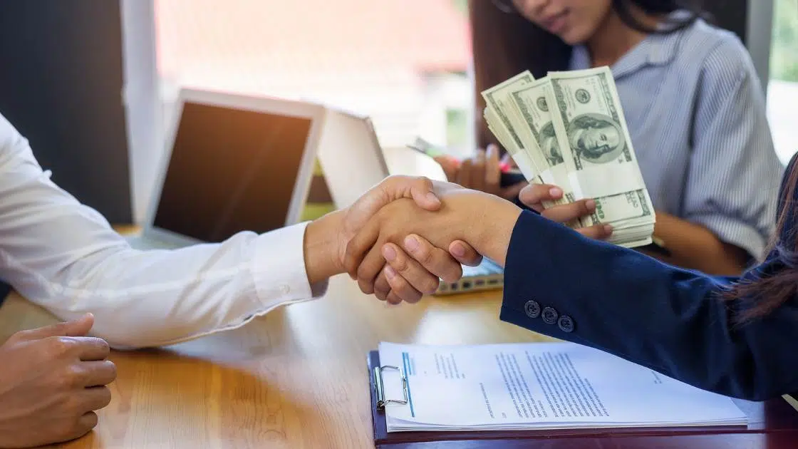a person shaking hand on loaned money deal